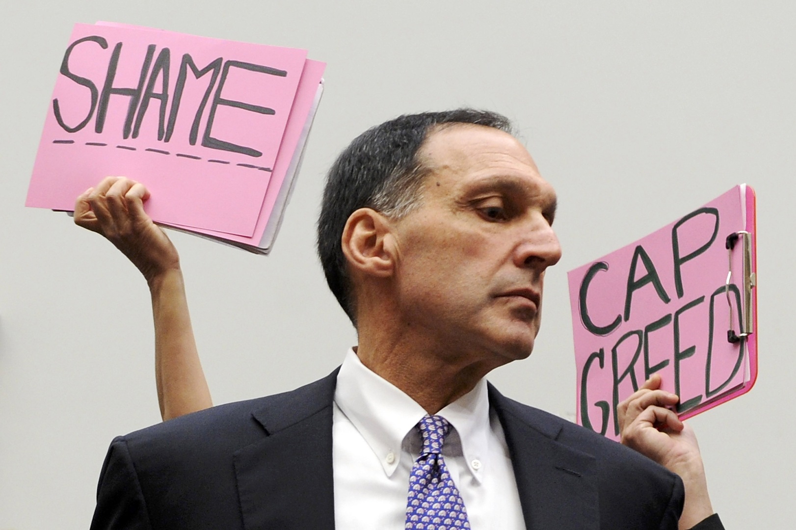 Protestors hold signs reading 
