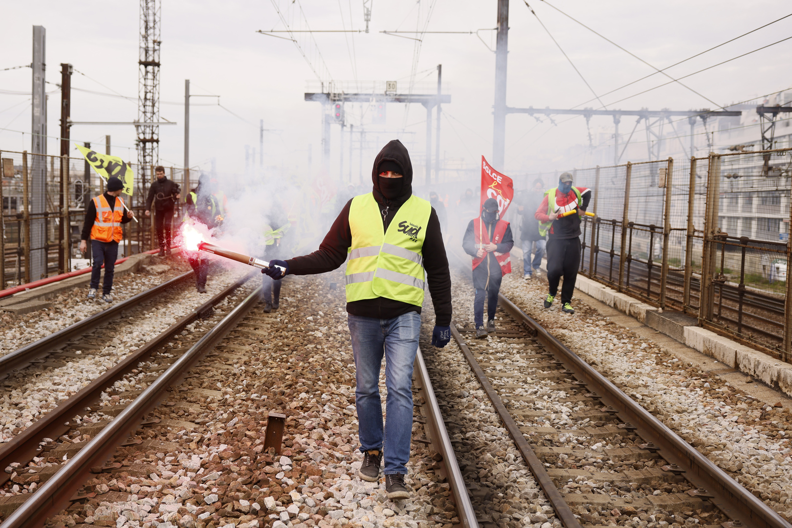 Railway workers protesting pension reforms on train tracks.